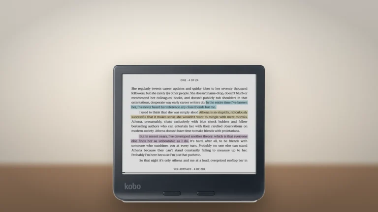 Black Kobo Libra Colour turned sideways on a wooden surface, showing a page of text with blue, yellow and purple highlights